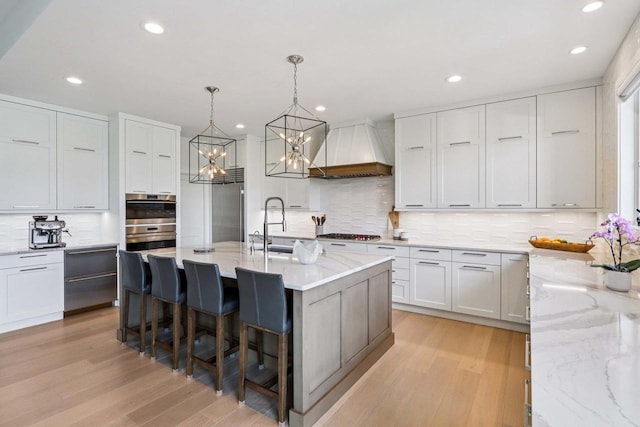 7678 Badger Run Ct, Verona, WI 53593 - kitchen featuring premium range hood, backsplash, light wood-type flooring, recessed lighting, and stainless steel appliances