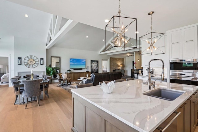 7678 Badger Run Ct, Verona, WI 53593 - kitchen featuring a sink, high vaulted ceiling, a chandelier, open floor plan, and decorative light fixtures