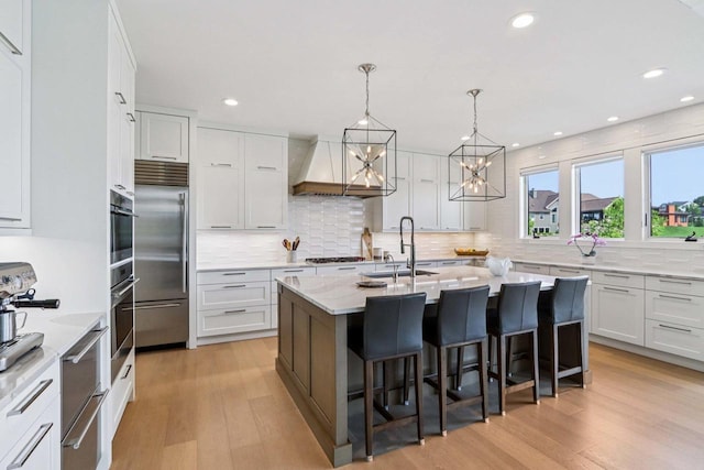 7678 Badger Run Ct, Verona, WI 53593 - kitchen with stainless steel appliances, a sink, light wood-style floors, tasteful backsplash, and recessed lighting