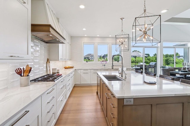 7678 Badger Run Ct, Verona, WI 53593 - kitchen featuring a sink, stainless steel gas cooktop, premium range hood, a chandelier, and recessed lighting
