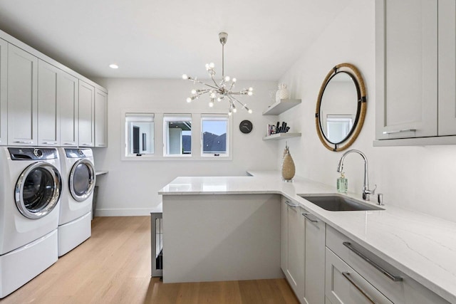 7678 Badger Run Ct, Verona, WI 53593 - washroom with cabinet space, washer and clothes dryer, light wood finished floors, a chandelier, and recessed lighting