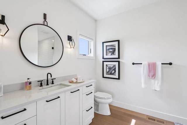 7678 Badger Run Ct, Verona, WI 53593 - bathroom with vanity, toilet, wood finished floors, a shower, and baseboards