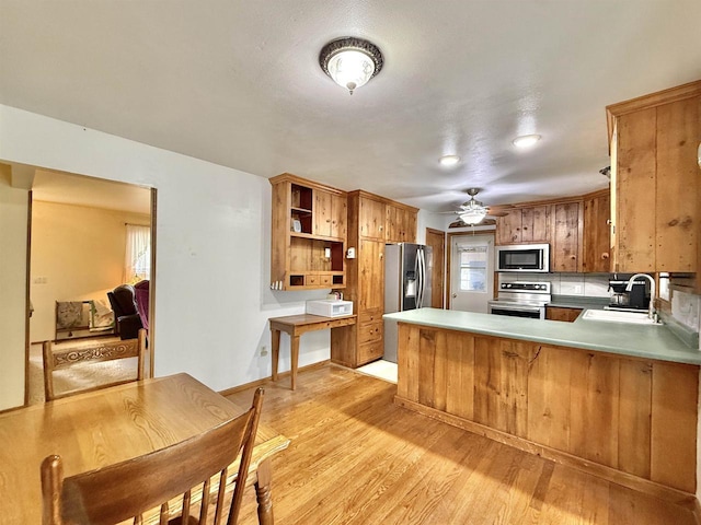 3117 Canterbury Ln, Janesville, WI 53546 - kitchen with appliances with stainless steel finishes, a sink, open shelves, light wood-style floors, and brown cabinetry