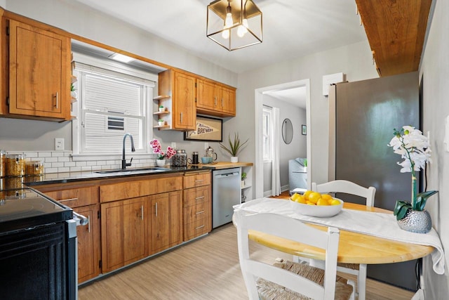 3725 Dawes St, Madison, WI 53714 - kitchen featuring appliances with stainless steel finishes, a sink, brown cabinets, light wood-type flooring, and dark countertops