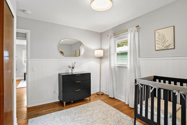 3725 Dawes St, Madison, WI 53714 - bedroom featuring wainscoting, wood finished floors, and a crib