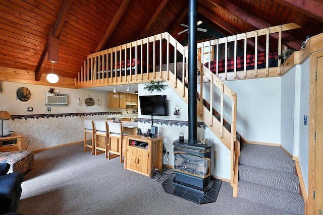 2775 Lake Rd, Barnes, WI 54873 - living area featuring carpet floors, wood ceiling, a wood stove, stairs, and a wall mounted air conditioner