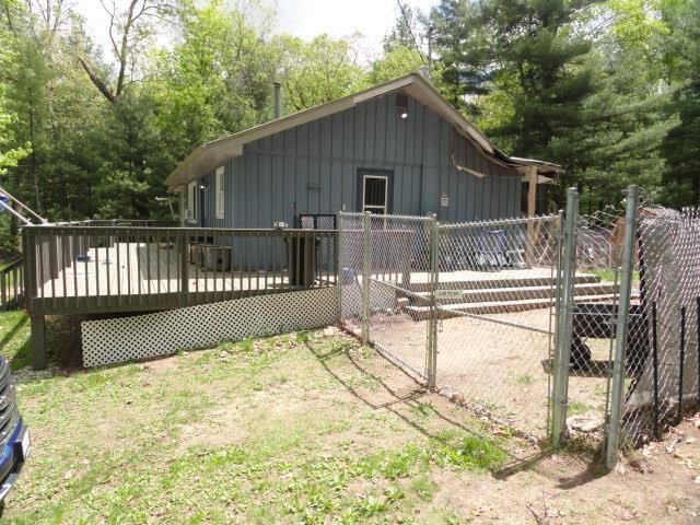 W4643 S Pearl Lake Rd, Redgranite, WI 54970 - rear view of house with board and batten siding and a deck