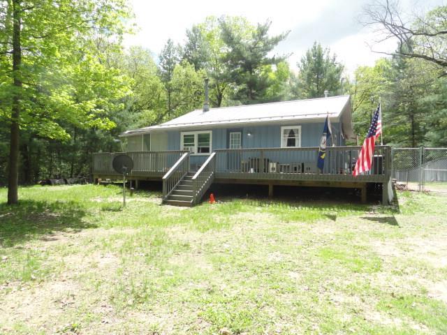 W4643 S Pearl Lake Rd, Redgranite, WI 54970 - rear view of house featuring a deck and view of wooded area