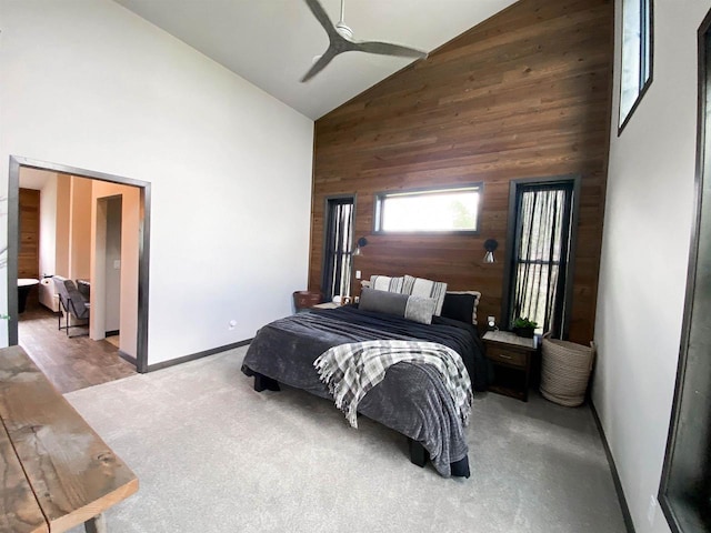 S7915 Ruthe Badger Ln, Merrimac, WI 53561 - carpeted bedroom featuring wood walls, high vaulted ceiling, baseboards, and ceiling fan
