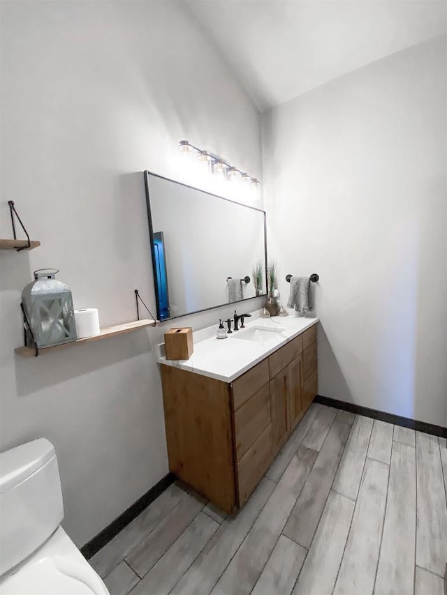S7915 Ruthe Badger Ln, Merrimac, WI 53561 - bathroom featuring wood tiled floors, vanity, toilet, and baseboards