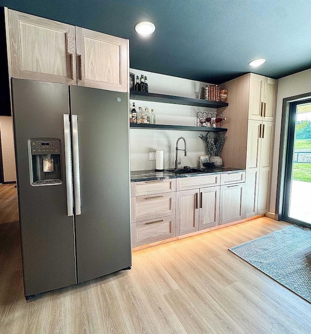 S7915 Ruthe Badger Ln, Merrimac, WI 53561 - kitchen with stainless steel fridge, a sink, open shelves, dark countertops, and light wood-style floors