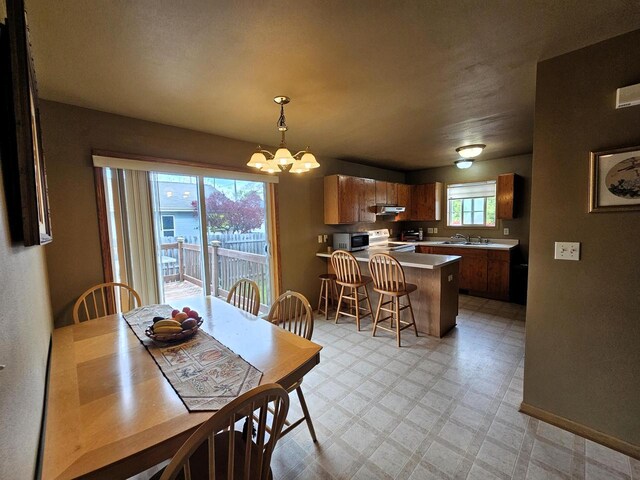 1114 W St, Racine, WI 53404 - dining space featuring light flooring, a chandelier, and baseboards
