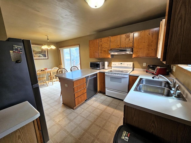1114 W St, Racine, WI 53404 - kitchen with appliances with stainless steel finishes, a peninsula, a sink, under cabinet range hood, and a chandelier