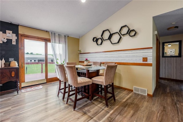 4868 183rd St, Chippewa Falls, WI 54729 - dining space featuring wood finished floors, vaulted ceiling, a textured ceiling, and baseboards