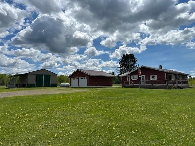 12258 Mosquito Brook Rd, Hayward, WI 54843 - view of grassy yard featuring driveway, a detached garage, and an outdoor structure