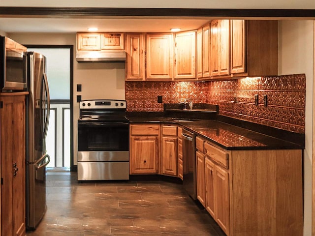 507 Janesville St, Oregon, WI 53575 - kitchen with stainless steel appliances, under cabinet range hood, decorative backsplash, and a sink