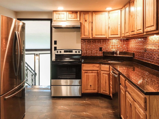 507 Janesville St, Oregon, WI 53575 - kitchen featuring stainless steel appliances, under cabinet range hood, a sink, backsplash, and dark countertops