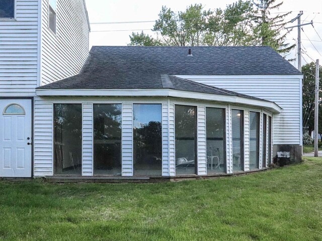 507 Janesville St, Oregon, WI 53575 - rear view of property featuring roof with shingles, a yard, and a sunroom