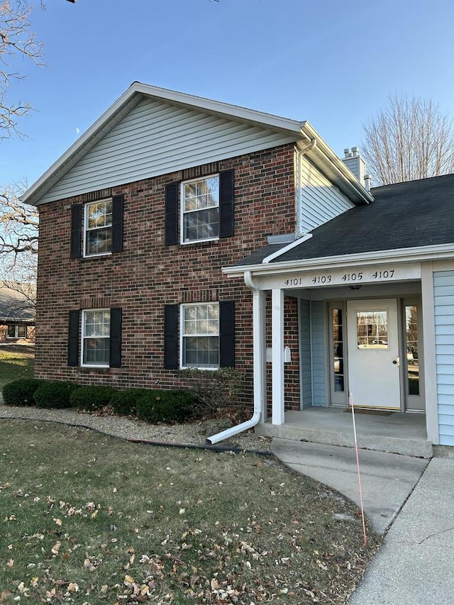 4103 80th St Unit 28A, Kenosha, WI 53142 - view of front of home featuring brick siding, a chimney, and a front lawn
