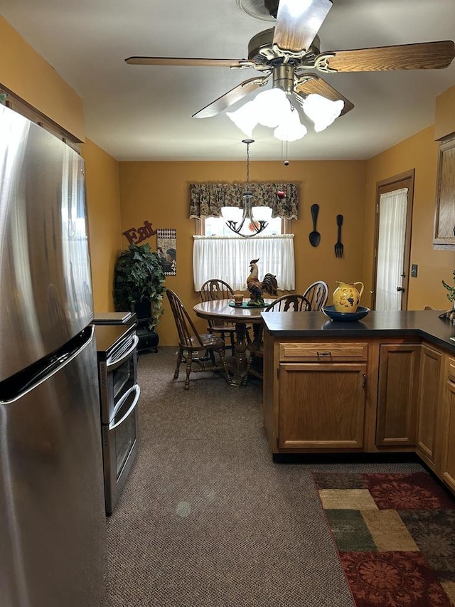 4103 80th St Unit 28A, Kenosha, WI 53142 - kitchen featuring stainless steel appliances, dark carpet, dark countertops, a ceiling fan, and brown cabinetry