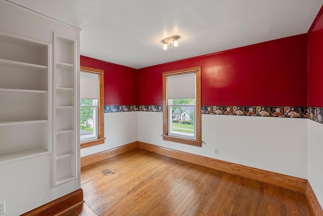 210 Gilmore Ave, Beaver Dam, WI 53916 - spare room featuring plenty of natural light, wood-type flooring, and baseboards