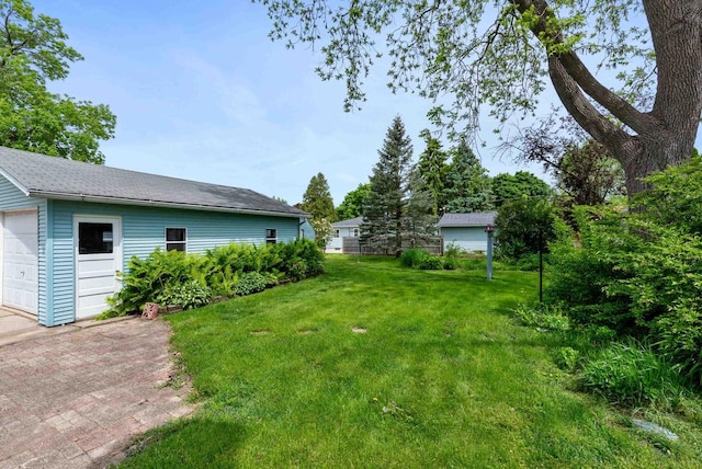 210 Gilmore Ave, Beaver Dam, WI 53916 - view of green lawn with a detached garage and an outdoor structure