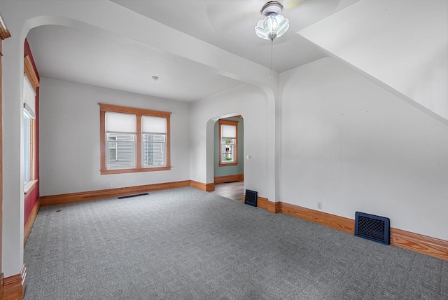 210 Gilmore Ave, Beaver Dam, WI 53916 - carpeted empty room featuring arched walkways, baseboards, and ceiling fan