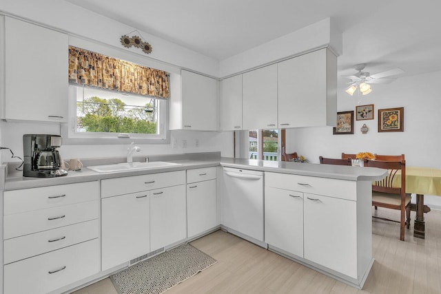 2117 N 27th St, Sheboygan, WI 53081 - kitchen with dishwasher, a sink, light countertops, a peninsula, and light wood finished floors