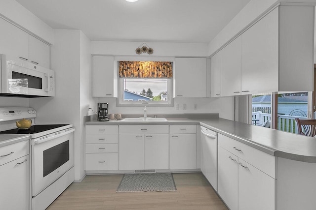 2117 N 27th St, Sheboygan, WI 53081 - kitchen featuring white appliances, a sink, healthy amount of natural light, and light wood-style flooring