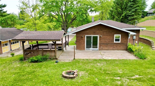 1217 Andover Ave, Eau Claire, WI 54703 - back of house featuring a lawn, a patio, a wooden deck, and a fire pit