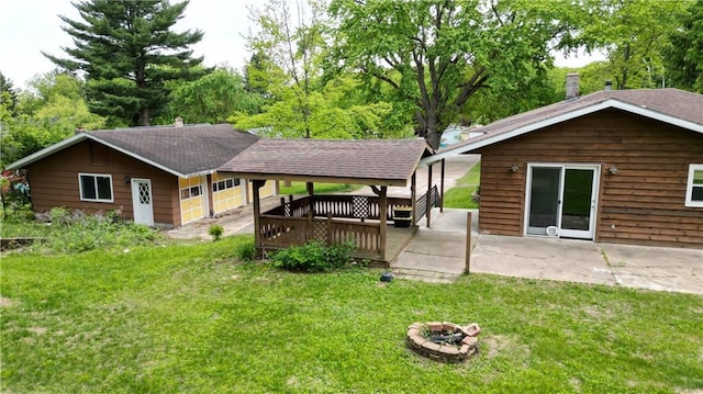 1217 Andover Ave, Eau Claire, WI 54703 - back of house with a fire pit, a yard, a wooden deck, and a patio