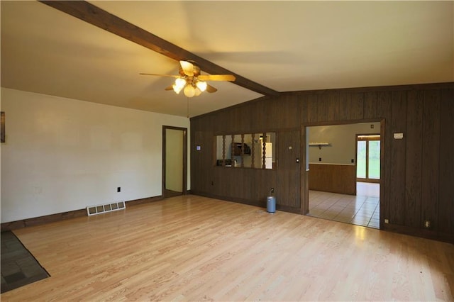 1217 Andover Ave, Eau Claire, WI 54703 - unfurnished living room featuring wood walls, wood finished floors, a ceiling fan, and baseboards