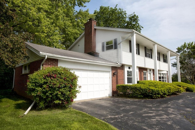 6538 N Bethmaur Ln, Glendale, WI 53209 - view of front of property with a chimney, asphalt driveway, brick siding, and a garage