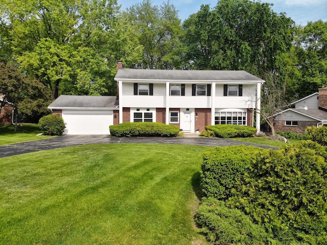 6538 N Bethmaur Ln, Glendale, WI 53209 - view of front facade with driveway, brick siding, a garage, and a front lawn