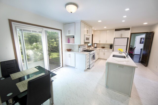 6538 N Bethmaur Ln, Glendale, WI 53209 - kitchen featuring white appliances, a sink, light countertops, white cabinetry, and an island with sink