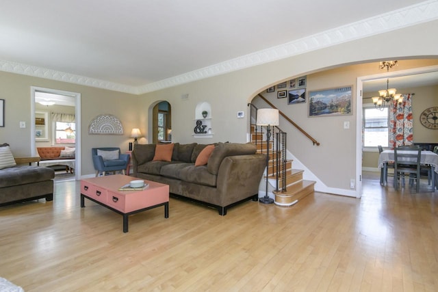 5744 W Rita Dr, West Allis, WI 53219 - living room with arched walkways, stairs, light wood-style floors, a chandelier, and baseboards