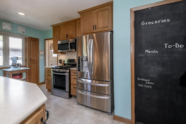 5744 W Rita Dr, West Allis, WI 53219 - kitchen with stainless steel appliances, light countertops, tasteful backsplash, light tile patterned flooring, and brown cabinets