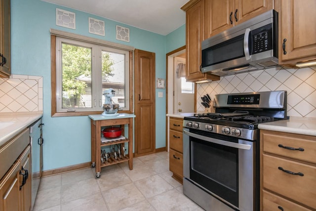 5744 W Rita Dr, West Allis, WI 53219 - kitchen with appliances with stainless steel finishes, backsplash, light countertops, and baseboards