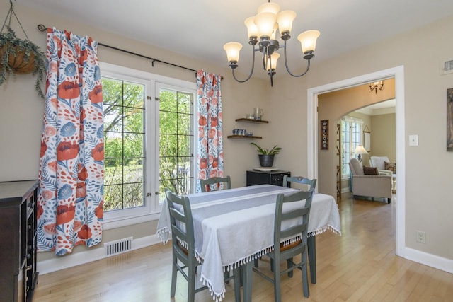 5744 W Rita Dr, West Allis, WI 53219 - dining area with a chandelier, arched walkways, wood finished floors, and baseboards
