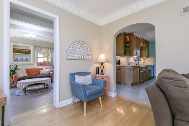 5744 W Rita Dr, West Allis, WI 53219 - sitting room featuring arched walkways, crown molding, light wood-style flooring, and baseboards