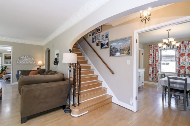 5744 W Rita Dr, West Allis, WI 53219 - stairs with a chandelier, arched walkways, ornamental molding, wood finished floors, and baseboards