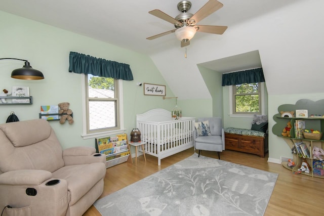 5744 W Rita Dr, West Allis, WI 53219 - bedroom featuring multiple windows, wood finished floors, vaulted ceiling, and a nursery area
