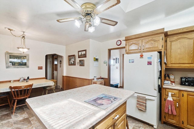 W7211 Pine Rd, Thorp, WI 54771 - kitchen with freestanding refrigerator, arched walkways, a ceiling fan, light countertops, and hanging light fixtures