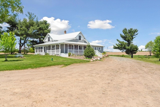W7211 Pine Rd, Thorp, WI 54771 - farmhouse-style home with dirt driveway, a porch, a chimney, and a front lawn