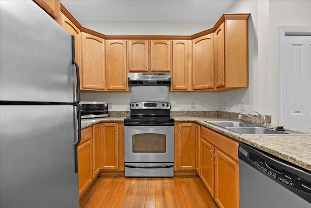 832 N 6th St Unit 118, Sheboygan, WI 53081 - kitchen featuring stainless steel appliances, under cabinet range hood, a sink, light wood-style floors, and light countertops
