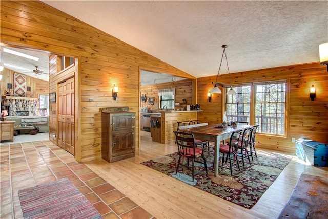 8360 W Shore Ln, Hayward, WI 54843 - dining room featuring wooden walls, vaulted ceiling, a skylight, a textured ceiling, and wood finished floors