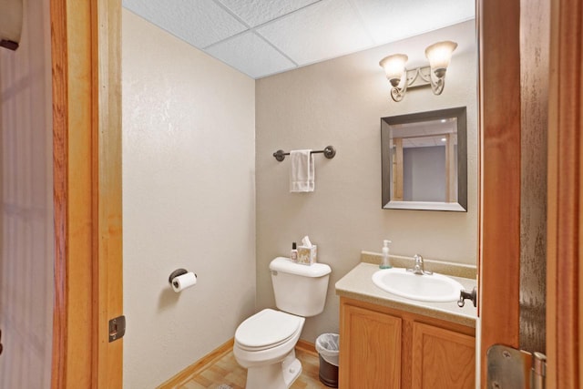 371 Thurow Dr, Oconomowoc, WI 53066 - half bathroom with vanity, toilet, a drop ceiling, and baseboards
