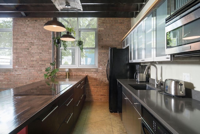3059 N Weil St Unit 124, Milwaukee, WI 53212 - kitchen with stainless steel microwave, brick wall, a sink, light tile patterned floors, and healthy amount of natural light