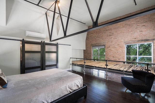 3059 N Weil St Unit 124, Milwaukee, WI 53212 - bedroom with a wall unit AC, a high ceiling, brick wall, a barn door, and wood finished floors