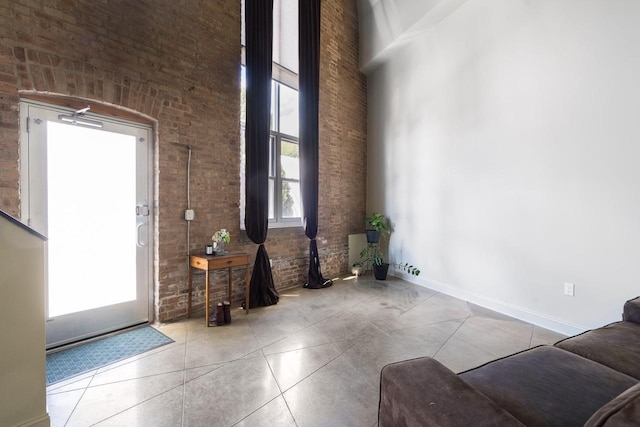 3059 N Weil St Unit 124, Milwaukee, WI 53212 - tiled foyer featuring a towering ceiling, baseboards, and brick wall